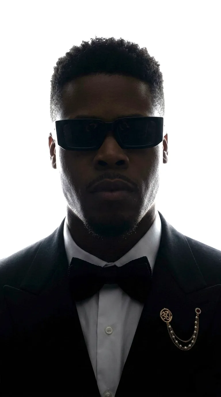 Meka Anyanwu in a black tuxedo and dark glasses